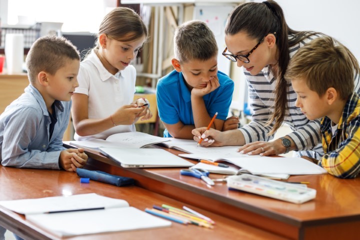 Leerkracht en kinderen op een basisschool