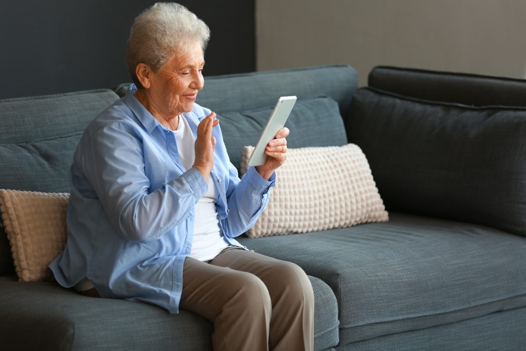 Blije oude vrouw bezig met telefoon